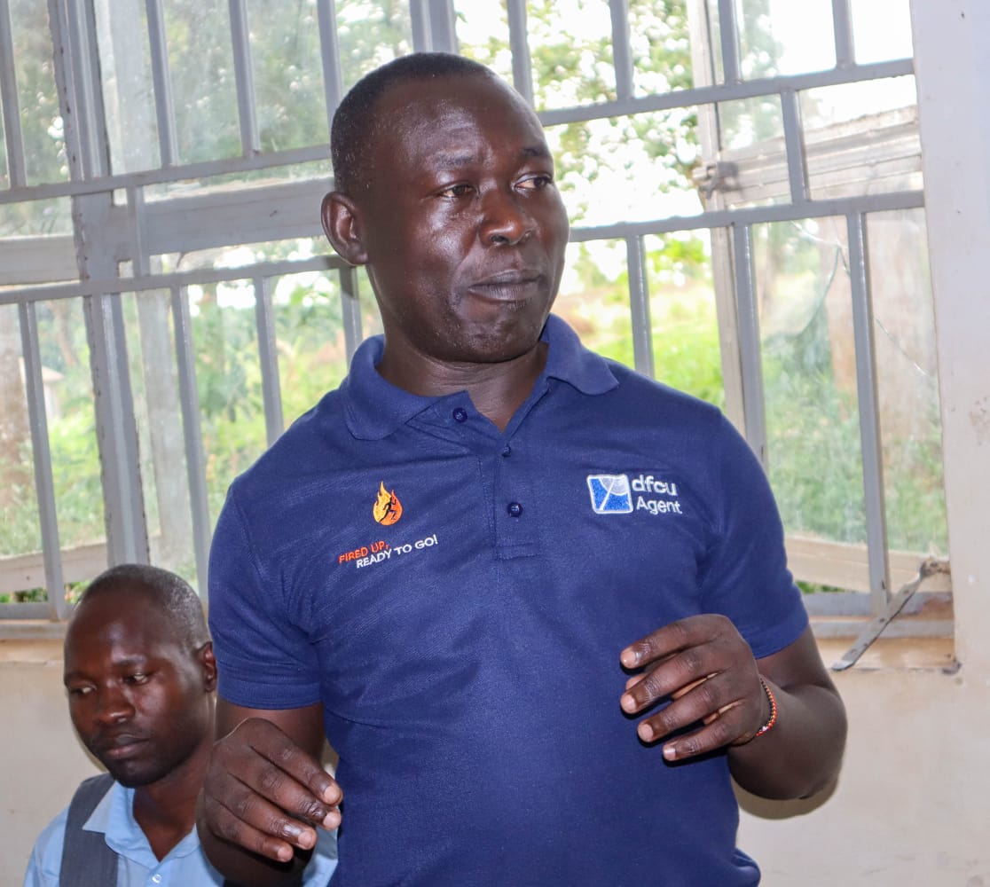 A dfcu Bank agent explaining the financing terms to the meeting